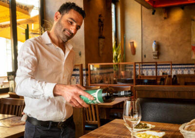 Mitarbeiter schenkt Wein in ein Glas ein im Tapas Barcelona Spanier in Dresden Altstadt