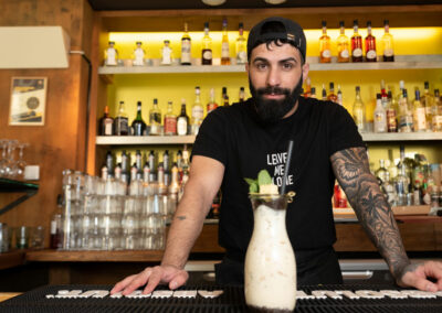 Mitarbeiter an Bar der Burgerei in Dresden präsentiert Cocktail